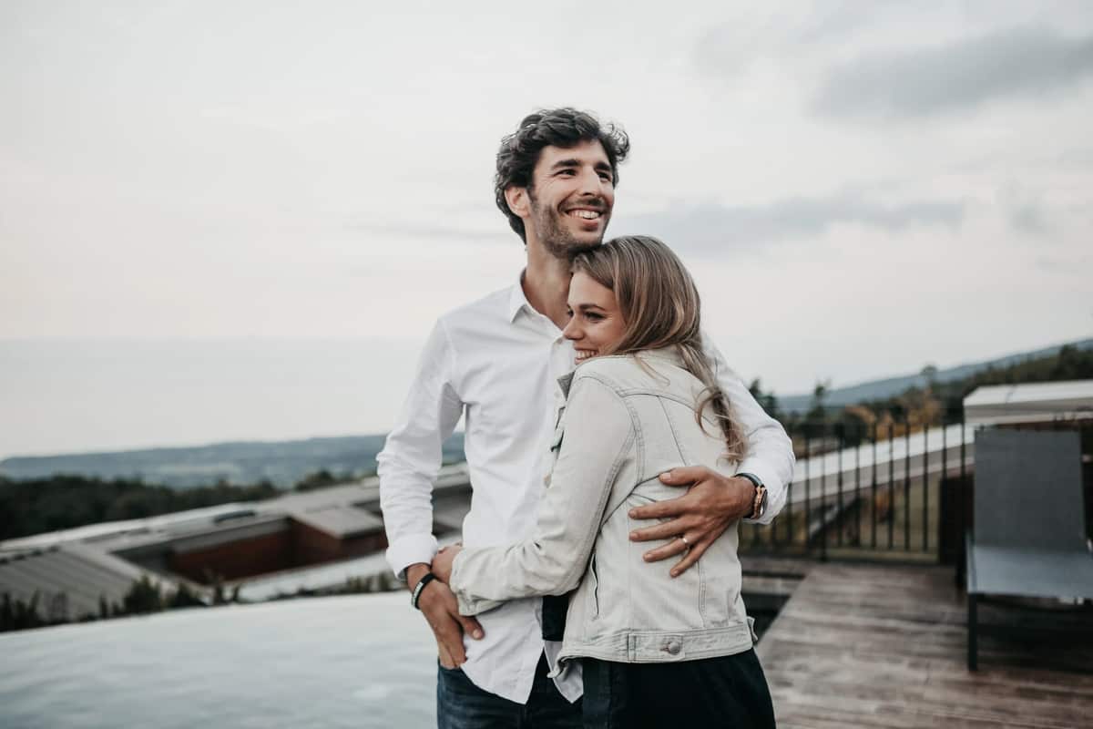 A smiling couple embracing on a rooftop terrace